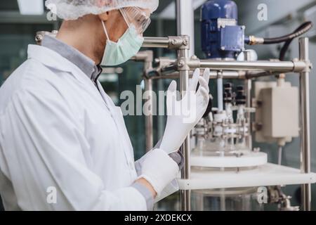 Scientist staff wearing Latex Medical Glove in Science Lab. Medical factory staff in clean room. Pharmaceutical Plants Process. Stock Photo