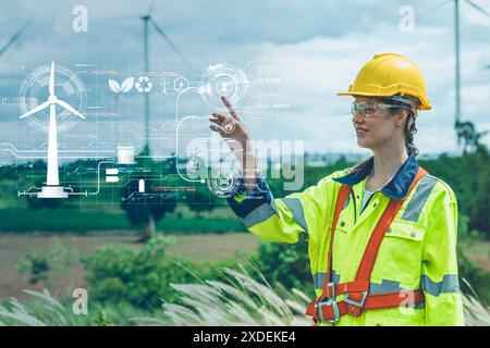 clean energy engineering concept, engineer women happy smile in wind turbin farm outdoor hand touch overlay power control panel graphic. Stock Photo