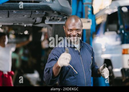 Portrait Happy Garage Mechanic African Black male smiling thumbs up looking camera. Stock Photo