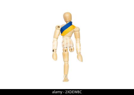 A wooden man without a leg with a Ukrainian flag on his chest will lose his leg in the war in Ukraine Stock Photo