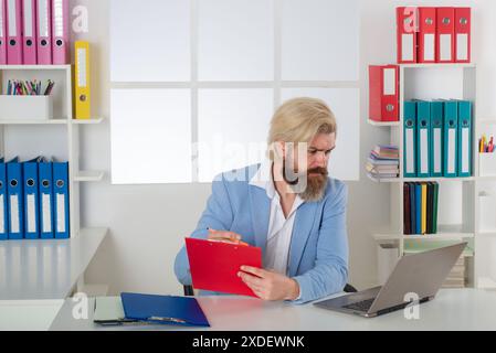 Accounting audit. Tax Accountant Advisor Man Doing Invoice Accounting. Serious and focused financier accountant on paper work in office. Mature man Stock Photo