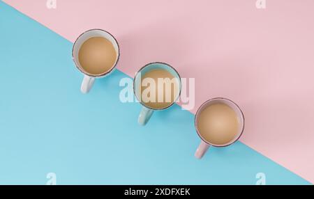 Three cups of coffee on pastel pink and blue background. Minimal coffee concept. Flat lay, top of view. Stock Photo