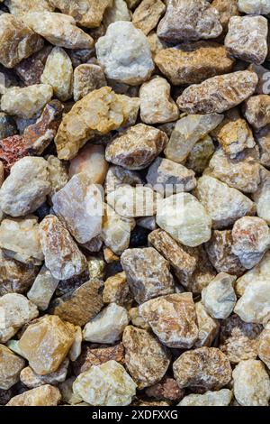 Close view of a collection of various stones and pebbles in different shapes, sizes, and colors, including shades of green, beige, and brown. Stock Photo