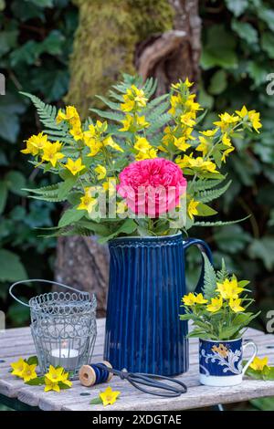 floral arrangement with bouquet of red rose, garden loosestrife and fern leaves in garden Stock Photo
