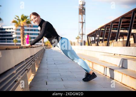 Active female runner in warm-up stretching for running or cardio exercise. Stock Photo