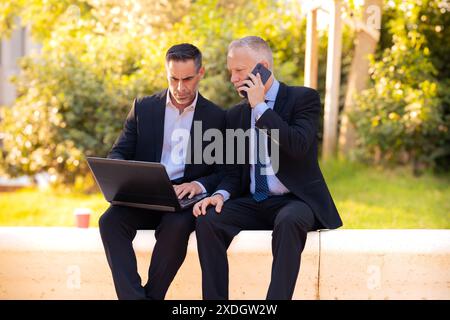 Two businessmen with laptop in hand looking at the results of the project. Stock Photo
