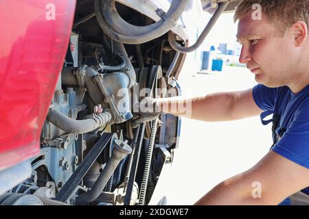 Professional mechanic inspects and repairs bus engine. Car maintenance. Stock Photo