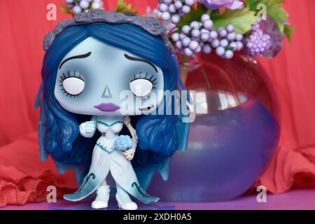 Funko Pop action figure of Emily from dark fantasy animated film Corpse Bride. Purple flowers, crimson curtain, glass ball, mysterious, romantic. Stock Photo