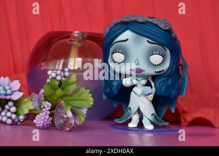 Funko Pop action figure of Emily from dark fantasy animated film Corpse Bride. Purple flowers, crimson curtain, glass ball, mysterious, romantic. Stock Photo