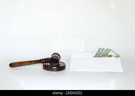 Judge's gavel and dollars in an envelope on a white background, corruption and bribery, law and court Stock Photo