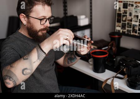 Creative photographer reviewing negatives in a modern home studio Stock Photo