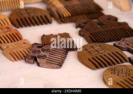 A collection of wooden hair combs with various designs and patterns. The combs are arranged in a circle on a white surface Stock Photo