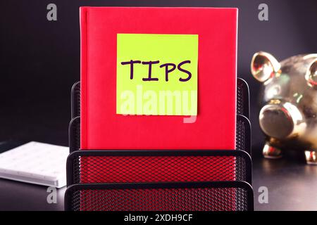 TIPS written on the sticker on the red business book Stock Photo
