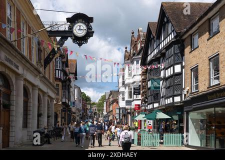 Visitors on the pedestrianised upper High Street, Winchester, with the 19th century clock and Grade II listed timber framed God Begot House, UK Stock Photo