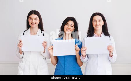 Doctors And Interns Holding Empty Papers, Standing In Hospital Stock Photo