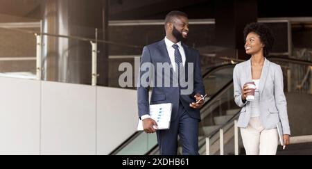 Two african american employees leaving office building for coffee break Stock Photo