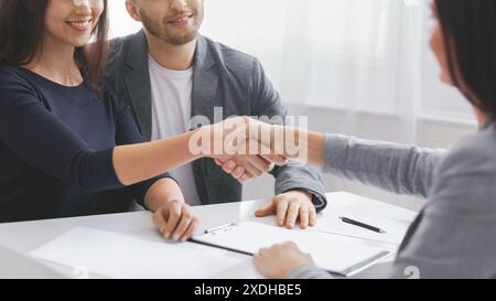 Couple Shaking Hands With Financial Advisor During a Meeting, Cropped Stock Photo