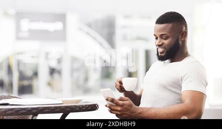 Man Using Smartphone and Coffee at Cafe Stock Photo