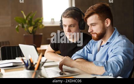 Two Men Working on a Laptop in Library Stock Photo