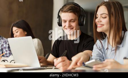Smiling Guy With Headphones Using Laptop in Group Study Session Stock Photo