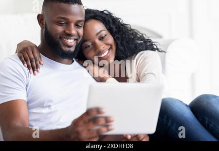 Couple Relaxing and Browsing on Tablet at Home Stock Photo