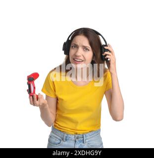 Confused woman in headphones with game controller on white background ...