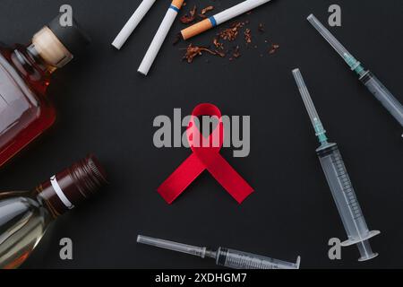 Flat lay composition with red awareness ribbon on black background Stock Photo