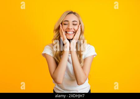 Delightful Woman With Long Blonde Hair On Yellow Stock Photo