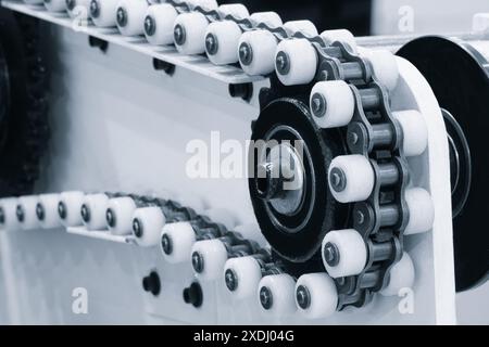 A chain with many white and black links. The chain is made of plastic and is used in a machine Stock Photo
