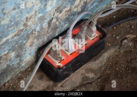 Old electrical plugs and sockets Placed on a damp surface, it may not be safe to use. Stock Photo