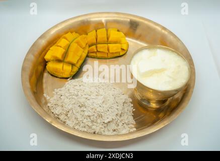 A copper plate and bowl of Dahi Chiura aka Yoghurt and Rice Flakes for ...