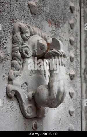 Clear stone knocker in the shape of a hand that holds a ball to be able to knock on the door. It has a base on which it is called. Stock Photo