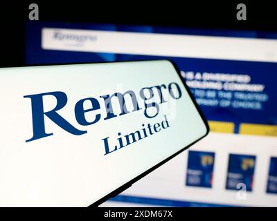 Smartphone with logo of South African investment company Remgro Limited in front of business website. Focus on center-left of phone display. Stock Photo