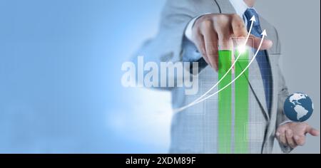 A businessman in a suit touching a virtual graph with upward arrows, indicating business growth and progress. This image signifies the use of technolo Stock Photo