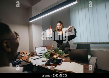 Young businesswoman presenting growth statistics during a team meeting in an office Stock Photo