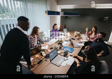 Diverse team of professionals collaborates on a project in a modern office setting Stock Photo