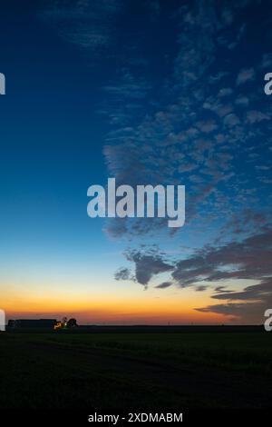 Altcumulus sheep clouds are beautifully illuminated by the twilight during a midsummer night in June Stock Photo