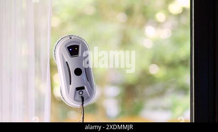 Window cleaning robot on glass with green background Stock Photo