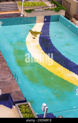 Damaged swimming pool on condominium property. Cleaning and repair of facing tiles. Stock Photo