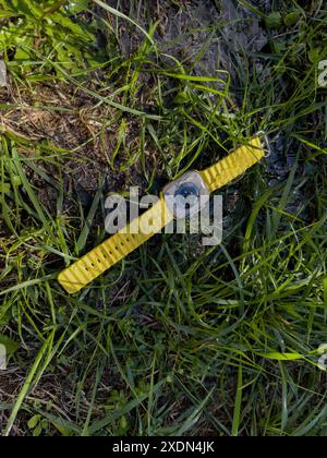 Paris, France - Sep 23, 2022: Lost Apple Watch Ultra smartwatch on the grass in the garden, covered with water, demonstrating its water resistance and Stock Photo