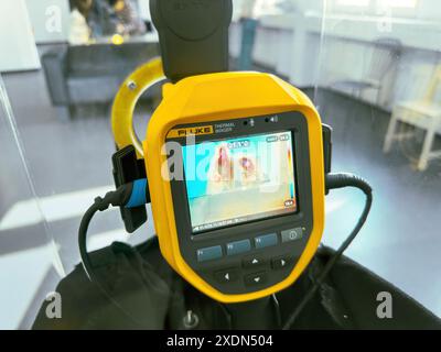 Frankfurt, Germany - Apr 1, 2024: A handheld Fluke thermal imager displaying a heat signature image on its screen, showing temperature readings, with Stock Photo