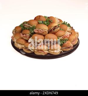 Platter of assorted deli sandwich sliders with sliced meats, cheese, and lettuce on soft buns, arranged for catering, parties, or buffet service. Stock Photo
