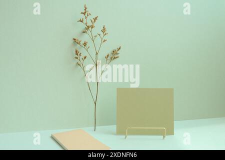 Workspace memo pad, note, dry flower on mint green desk background Stock Photo