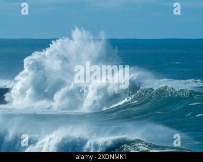 Large waves crashing over rocks on an island, big surf curling over and spraying into the air, salt water, Mid North coast NSW Australia Stock Photo