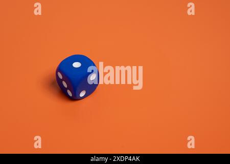 Blue dice on orange background. Copy space for text. Luck, risk and choice concept. Stock Photo