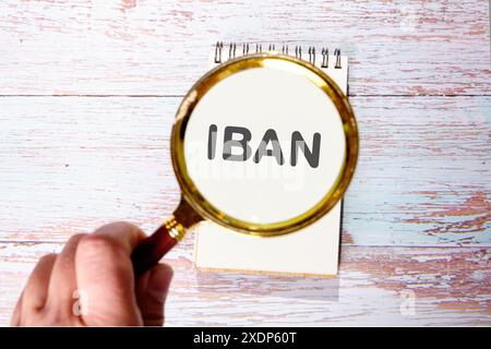 Business concept. IBAN INTERNATIONAL BANK ACCOUNT NUMBER words found using a magnifying glass in a notebook Stock Photo