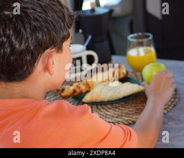 boy having breakfast in camper van interior Stock Photo