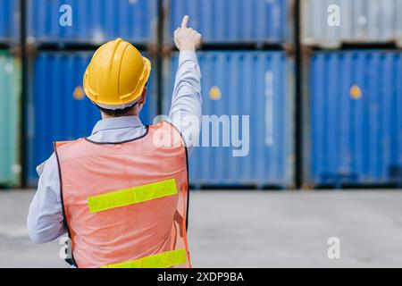 Success male worker standing hand point high for order operate control work in cargo shipping logistic industry. Stock Photo