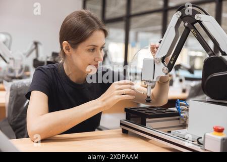 Engineer women learning education in Industrial Robotics program with robot arm simulation model in university engineering lab classroom. Stock Photo