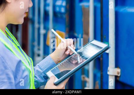 Closeup Logistic Worker industry using Online Tablet Technology Application Tracking Cargo Container World Wide Management. Stock Photo